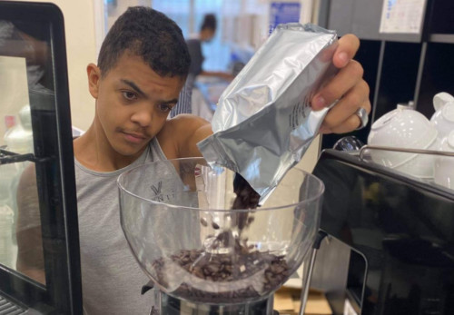 Student making a drink using a coffee machine